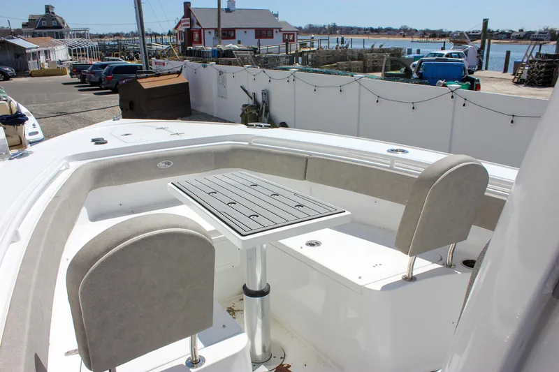 Slide: The Image of 2025 Sea Hunt Ultra 275 SE boat with seating and table, docked at a marina. - 20