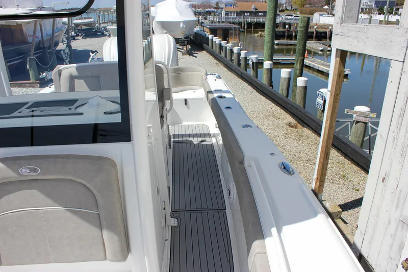 Slide: The Image of 2025 Sea Hunt Ultra 275 SE boat docked, showcasing sleek deck design and seating area. - 25