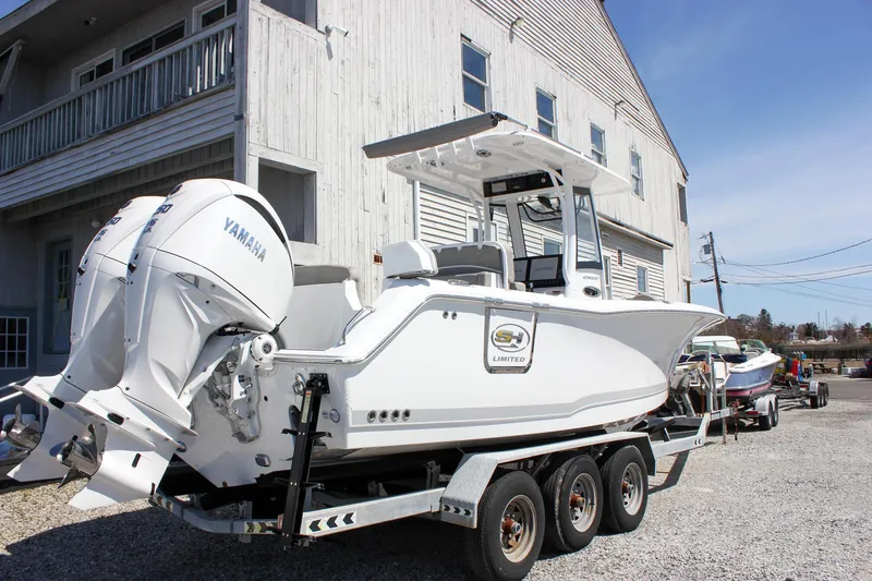 Slide: The Image of 2025 Sea Hunt Ultra 275 SE boat on trailer, featuring Yamaha engines, parked near a building. - 28