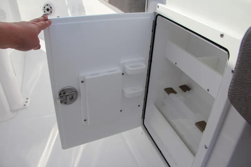 Slide: The Image of 2025 Sea Hunt Ultra 275 SE boat storage compartment with open door, showcasing interior features. - 36