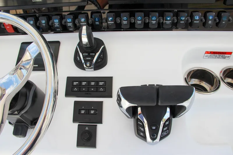 Slide: The Image of Control panel of 2025 Sea Hunt Ultra 275 SE boat with steering wheel and switches. - 39