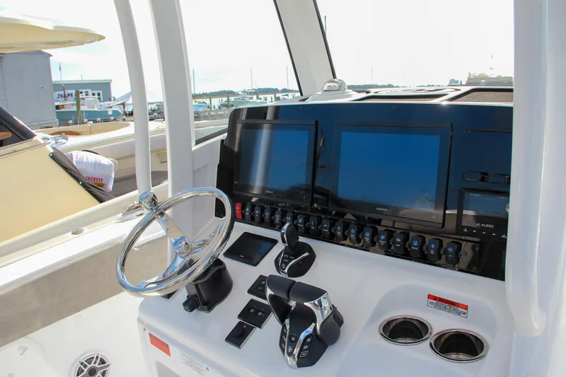 Slide: The Image of 2025 Sea Hunt Ultra 275 SE boat dashboard with dual screens and steering wheel. - 4