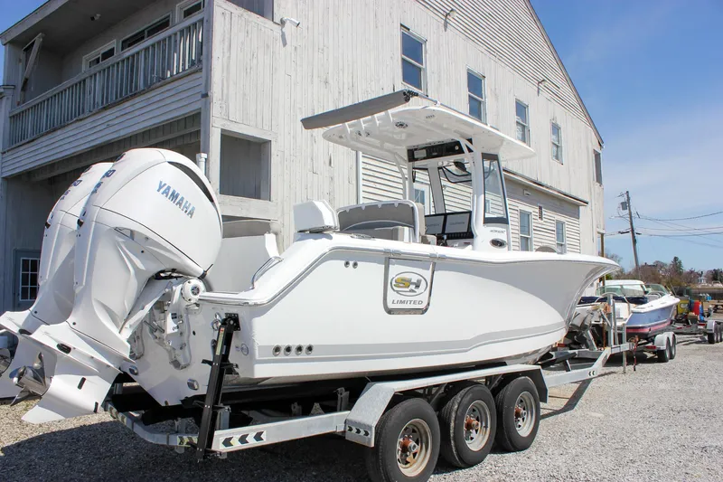 Slide: The Image of 2025 Sea Hunt Ultra 275 SE boat on trailer, parked near a building. - 5