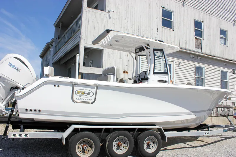 Slide: The Image of 2025 Sea Hunt Ultra 275 SE boat on trailer, parked near a building. - 51