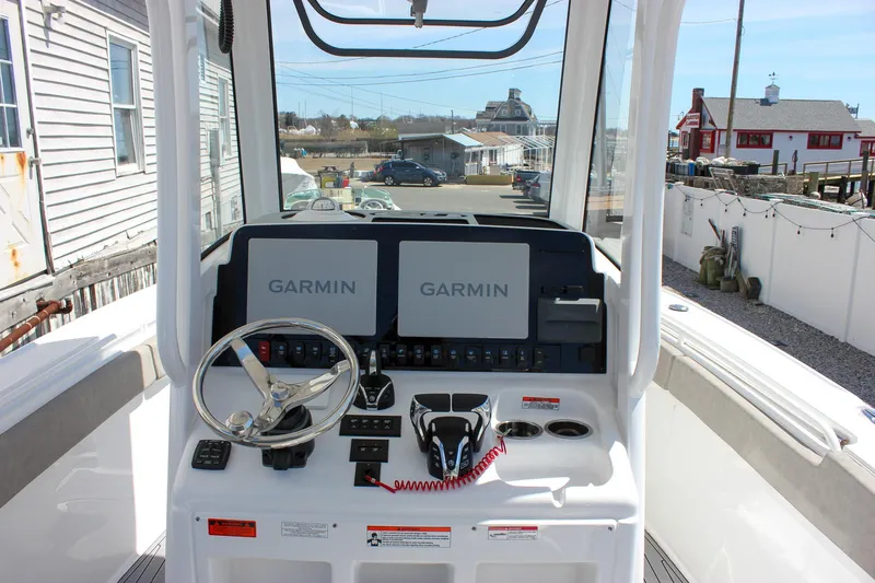 Slide: The Image of 2025 Sea Hunt Ultra 275 SE boat dashboard with dual Garmin displays and steering wheel. - 9