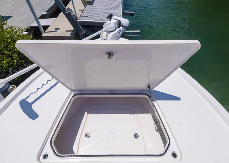 Slide: The Image of 2023 Caymas 28 HB boat with open storage compartment at the bow, dockside view. - 11