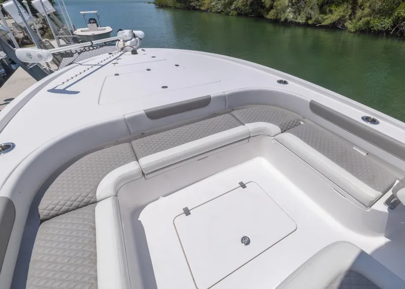 Slide: The Image of 2023 Caymas 28 HB boat with spacious seating and storage, docked by a serene waterway. - 14