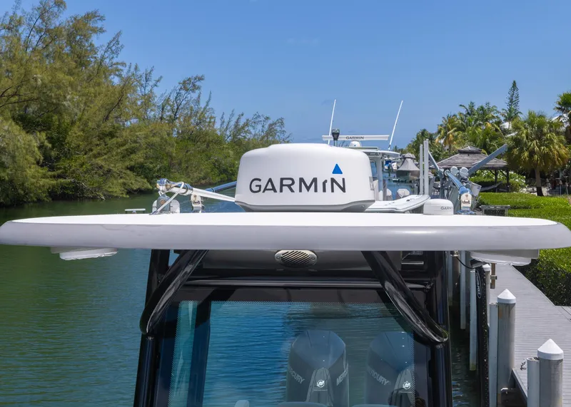 Slide: The Image of 2023 Caymas 28 HB boat with Garmin radar, docked by a scenic waterway. - 16