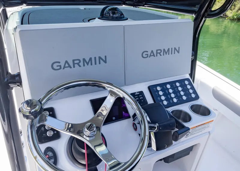 Slide: The Image of 2023 Caymas 28 HB boat dashboard with Garmin displays and steering wheel. - 17