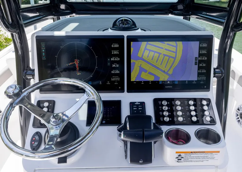 Slide: The Image of 2023 Caymas 28 HB boat dashboard with dual navigation screens and steering wheel. - 18