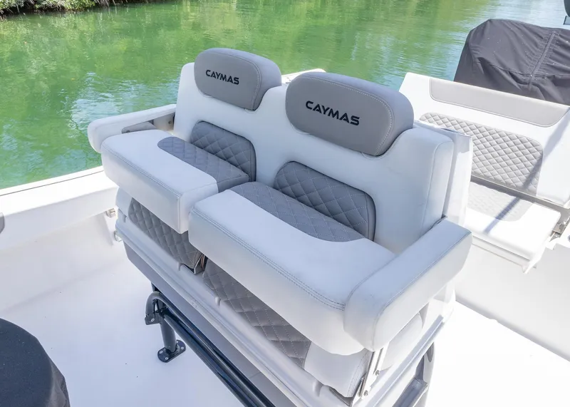Slide: The Image of 2023 Caymas 28 HB boat seats with gray and white upholstery, near water. - 21