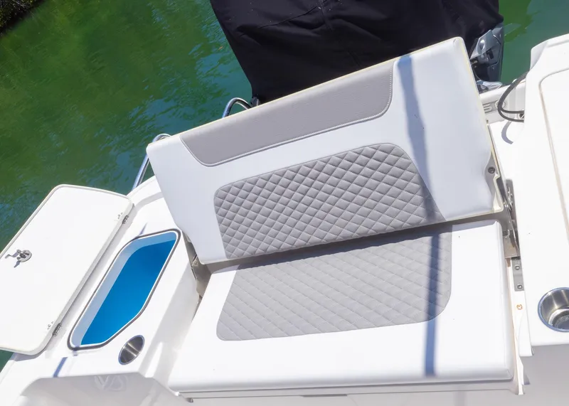 Slide: The Image of 2023 Caymas 28 HB boat seat with quilted design, adjacent to storage compartment. - 24