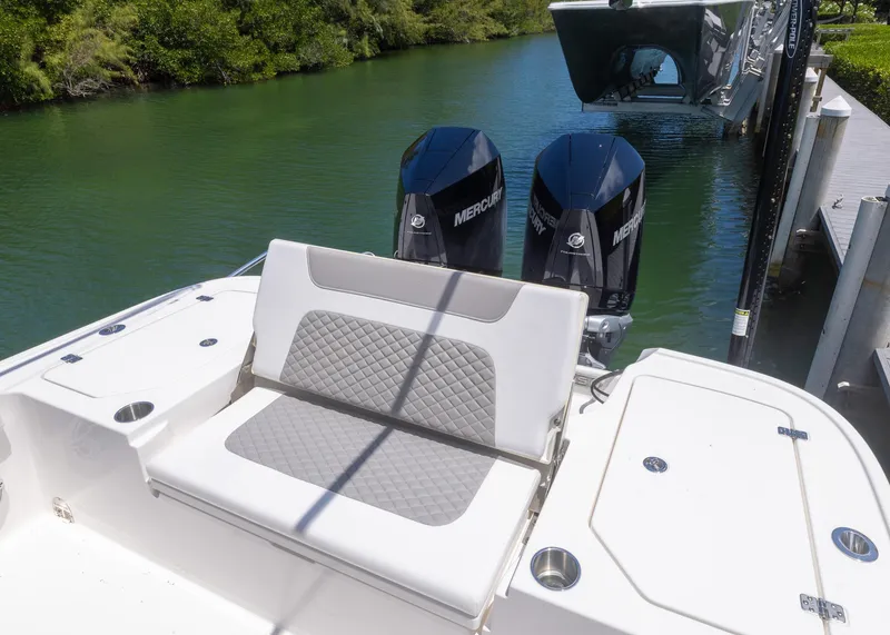 Slide: The Image of 2023 Caymas 28 HB boat with dual Mercury engines, docked on a sunny day. - 25