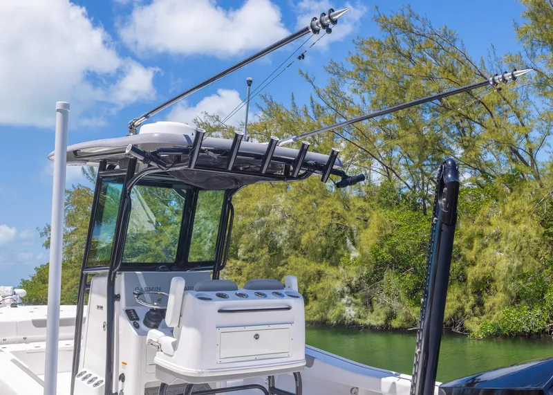 Slide: The Image of 2023 Caymas 28 HB boat with fishing rods, set against a lush, green backdrop. - 28