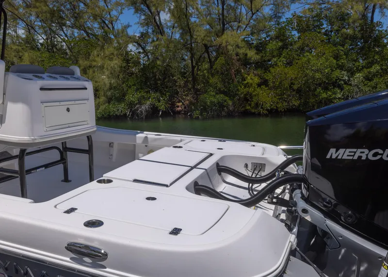 Slide: The Image of 2023 Caymas 28 HB boat with Mercury engine, docked near lush greenery. - 29