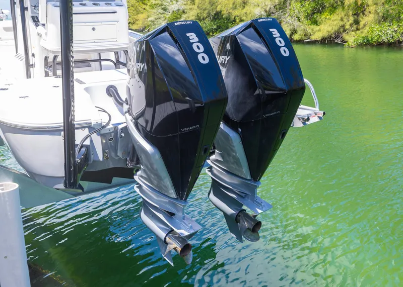 Slide: The Image of 2023 Caymas 28 HB boat with twin 300 horsepower Mercury outboard engines on a calm waterway. - 3