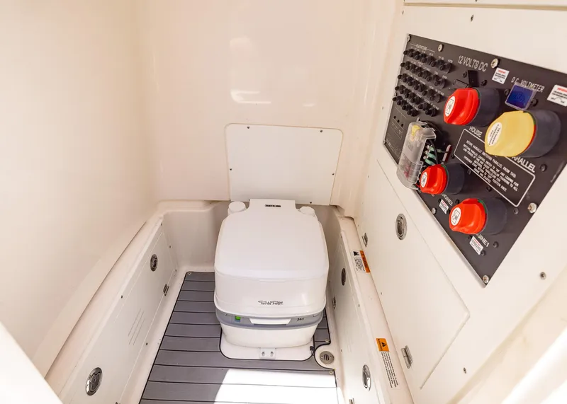 Slide: The Image of 2023 Caymas 28 HB boat interior with portable toilet and control panel. - 32