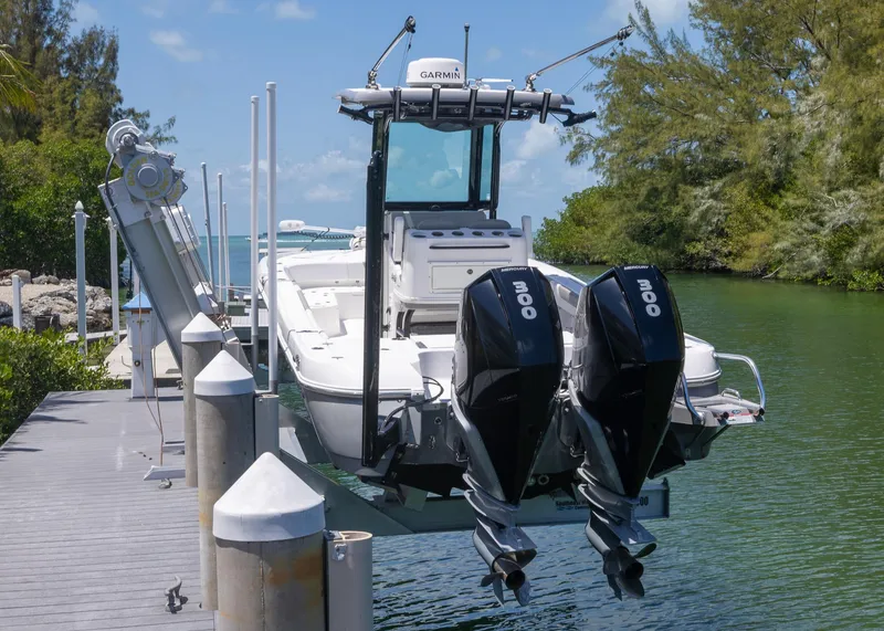 Slide: The Image of 2023 Caymas 28 HB boat docked with dual engines, surrounded by lush greenery. - 4