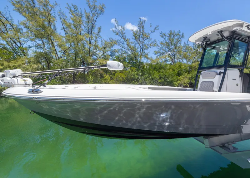 Slide: The Image of 2023 Caymas 28 HB boat on clear water with lush greenery background. - 5