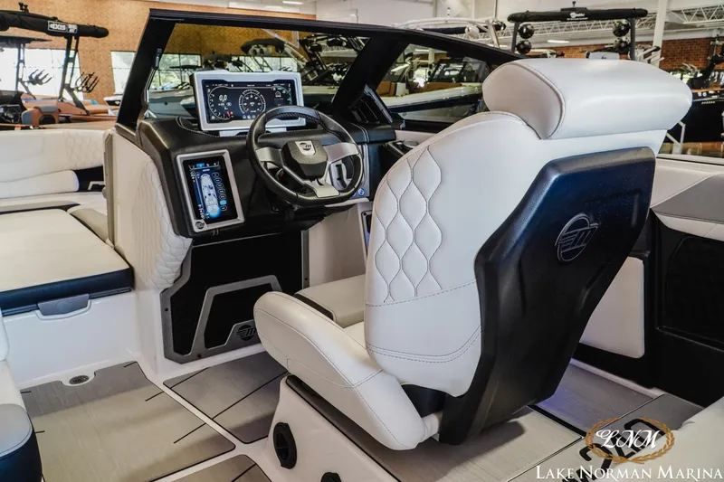Slide: The Image of Interior of a 2021 Malibu M240 boat featuring a modern dashboard and steering wheel. - 11