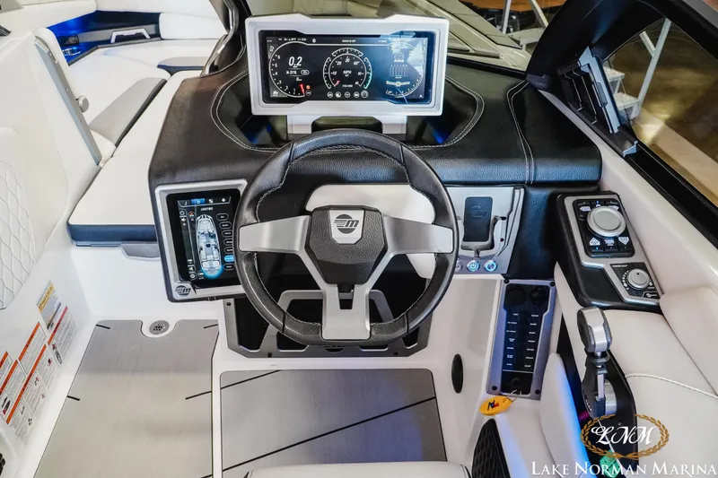 Slide: The Image of 2021 Malibu M240 boat dashboard with advanced controls and digital displays at Lake Norman Marina. - 12