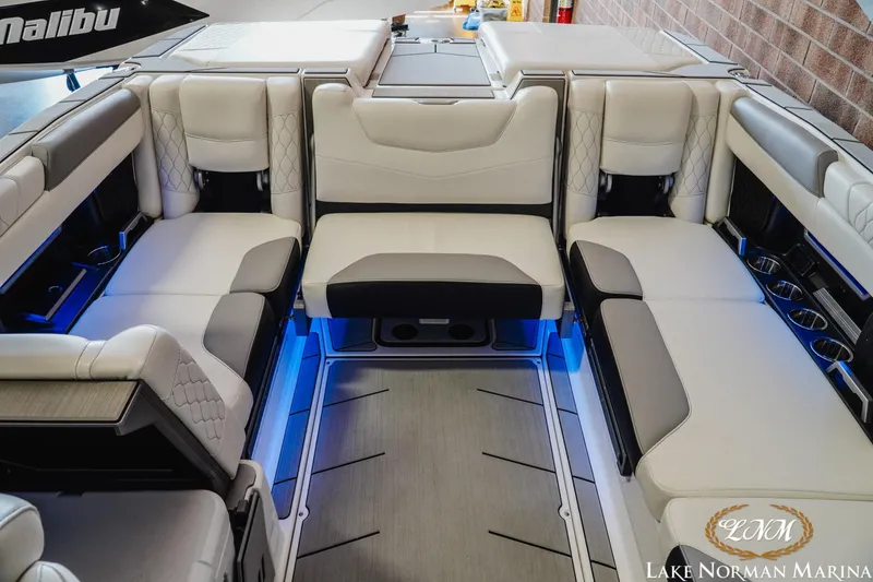 Slide: The Image of 2021 Malibu M240 boat interior with luxurious seating and ambient blue lighting. - 18