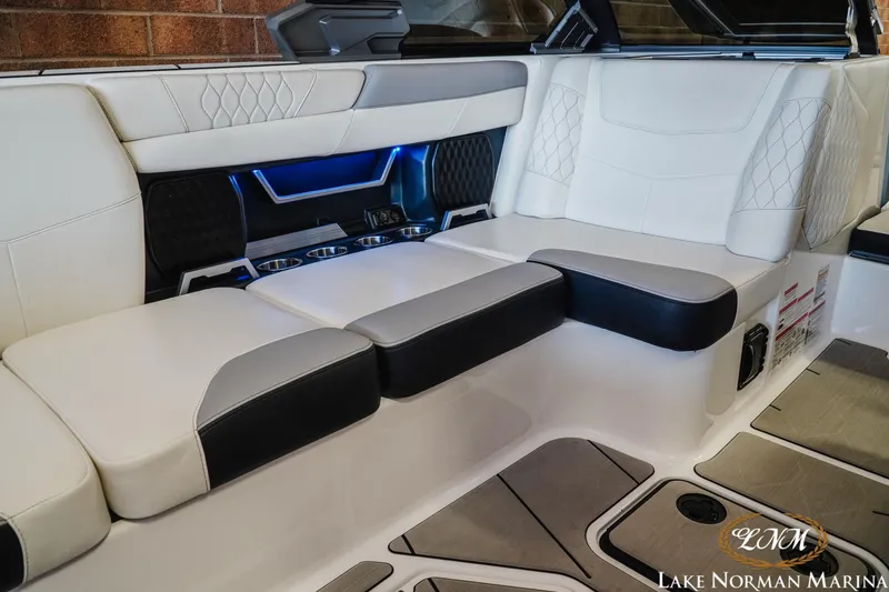 Slide: The Image of 2021 Malibu M240 boat interior with luxurious white seating and blue LED lighting. - 19
