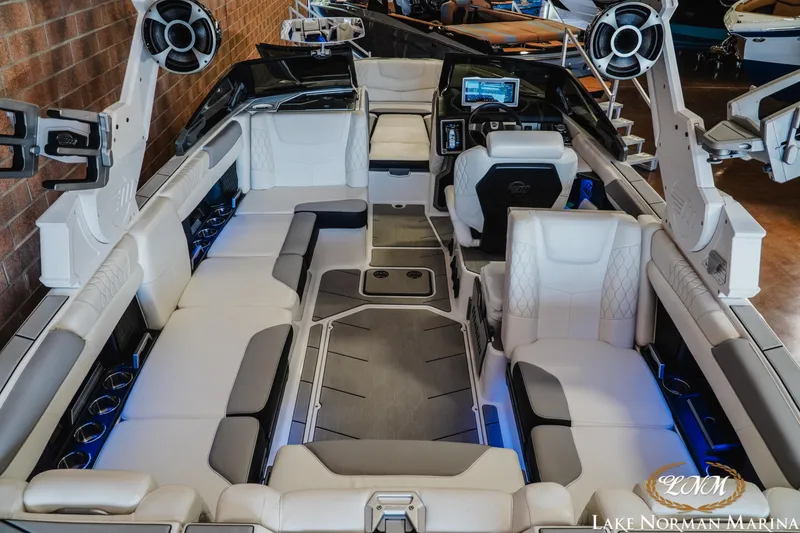 Slide: The Image of 2021 Malibu M240 boat interior with luxurious seating and advanced dashboard at Lake Norman Marina. - 8