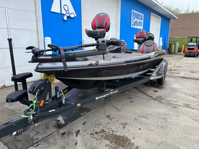 Slide: The Image of 2023 Ranger Z521R fishing boat on trailer, parked outside a blue building. - 3