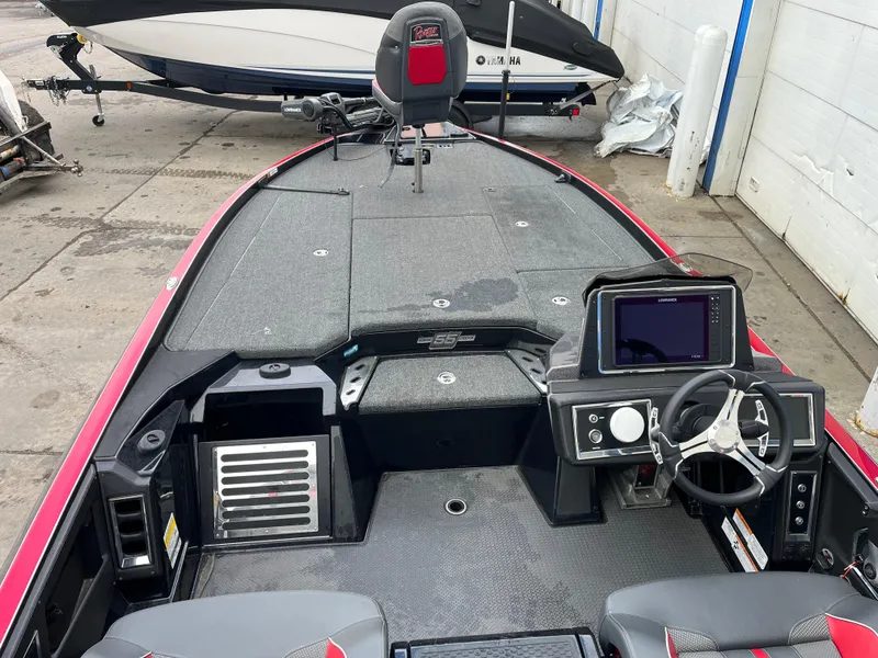 Slide: The Image of 2023 Ranger Z521R boat interior with steering wheel and control panel, docked in a marina. - 7