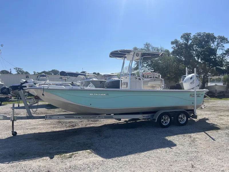 Slide: The Image of 2021 Carolina Skiff 25 LS boat on trailer, parked outdoors under clear sky. - 6