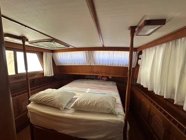Slide: The Image of 1987 Albin Double Cabin interior with bed, wooden finish, and curtained windows. - 16