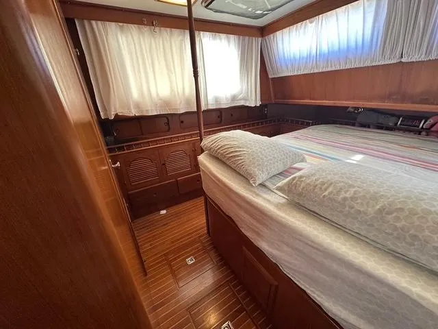 Slide: The Image of 1987 Albin Double Cabin interior with wood paneling and cozy bed setup. - 17