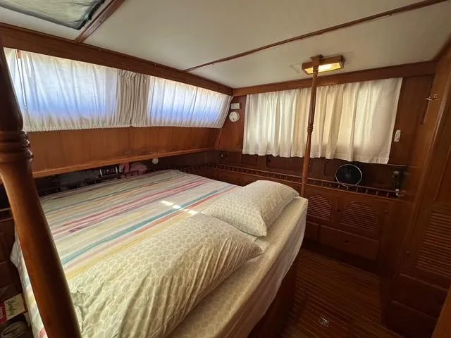 Slide: The Image of 1987 Albin Double Cabin interior with cozy bed, wooden paneling, and soft lighting. - 18