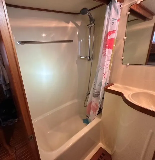 Slide: The Image of 1987 Albin Double Cabin bathroom with shower, curtain, and sink. - 19