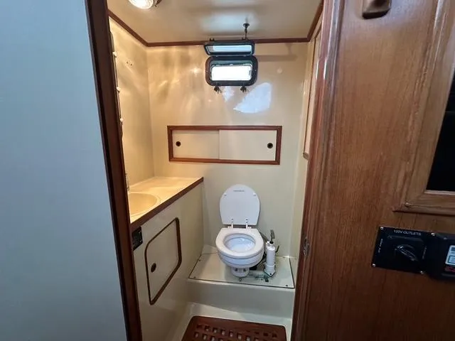 Slide: The Image of 1987 Albin Double Cabin bathroom with toilet, sink, and wooden accents. - 26