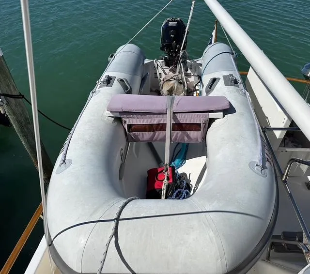 Slide: The Image of Inflatable boat on 1987 Albin Double Cabin yacht, docked on calm water. - 28