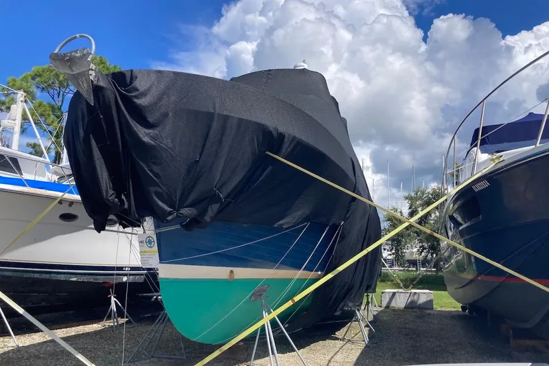 Slide: The Image of 1987 Albin Double Cabin Trawler covered, docked under a cloudy sky. - 35