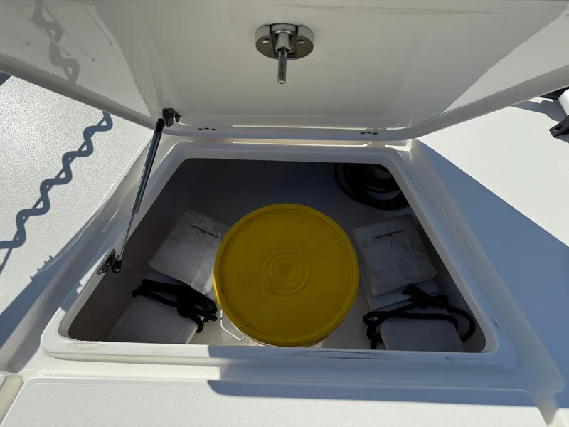 Slide: The Image of Open storage compartment on 2020 Key West 210 BR boat with yellow bucket inside. - 12