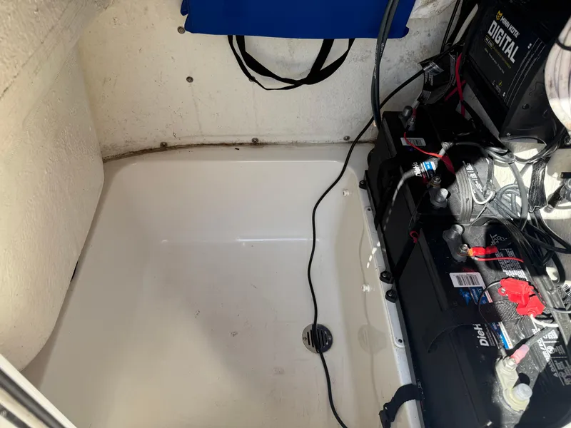 Slide: The Image of Battery compartment of a 2020 Key West 210 BR boat, featuring wiring and drainage. - 20