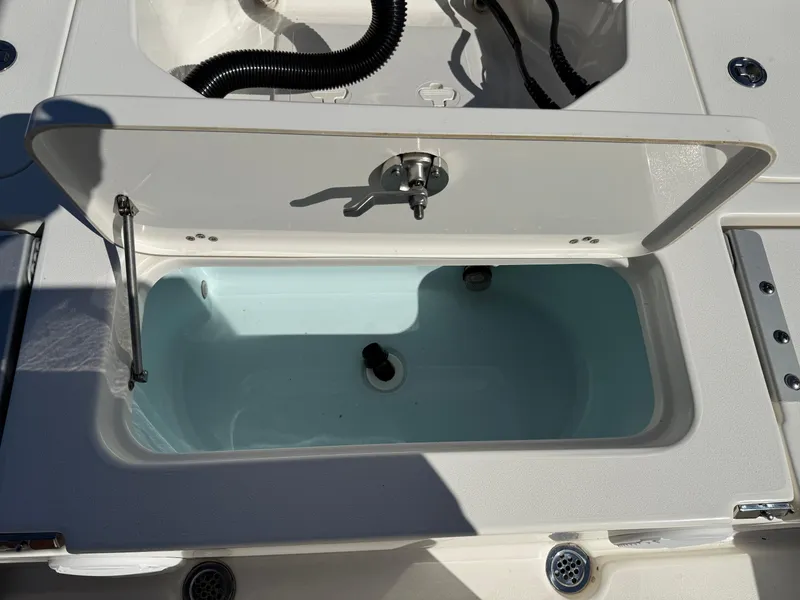 Slide: The Image of Open storage compartment on a 2020 Key West 210 BR boat, featuring a clean interior. - 24