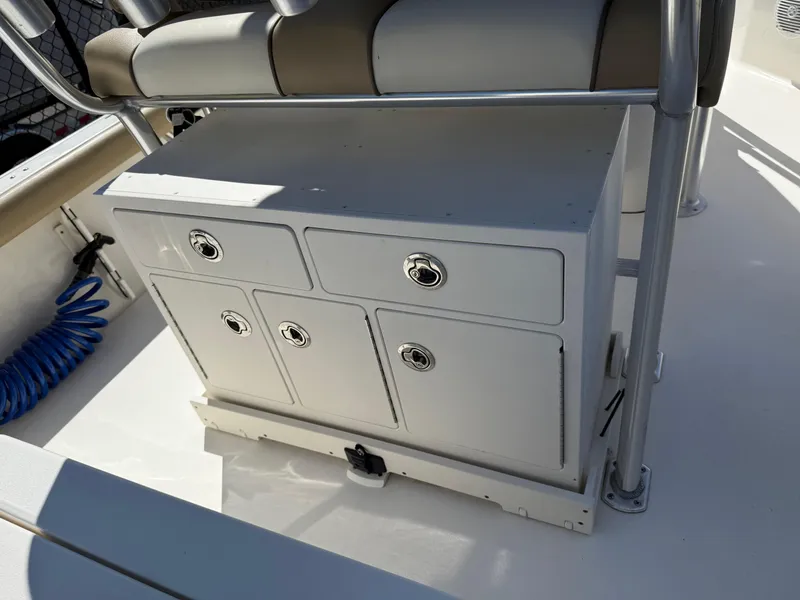 Slide: The Image of 2020 Key West 210 BR boat storage compartment with cushioned seating and metal frame. - 31