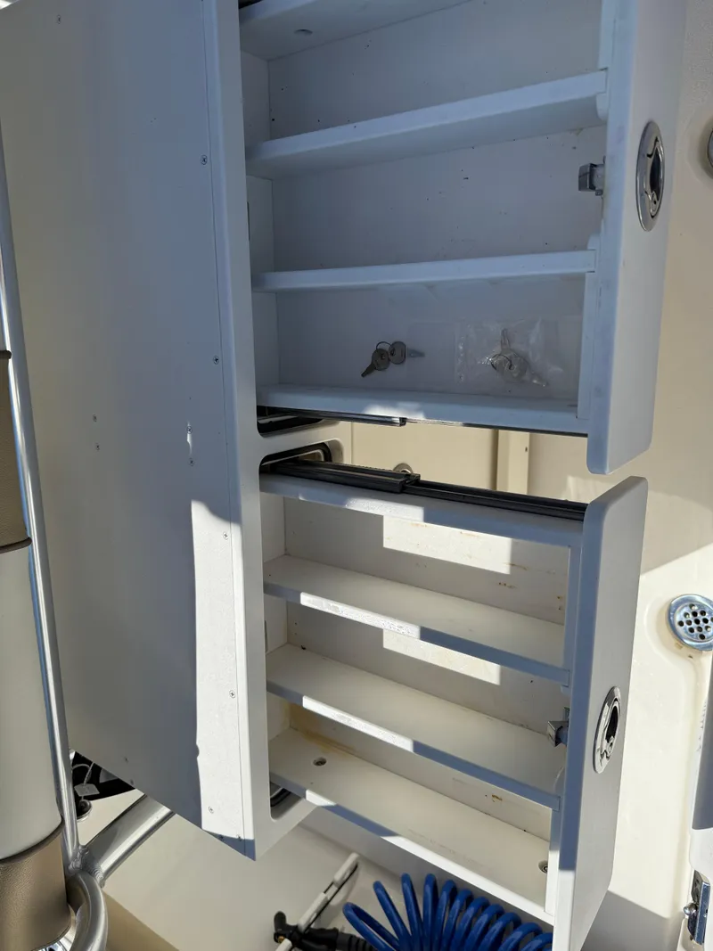 Slide: The Image of Open storage compartments on a 2020 Key West 210 BR boat, showcasing interior shelving. - 32