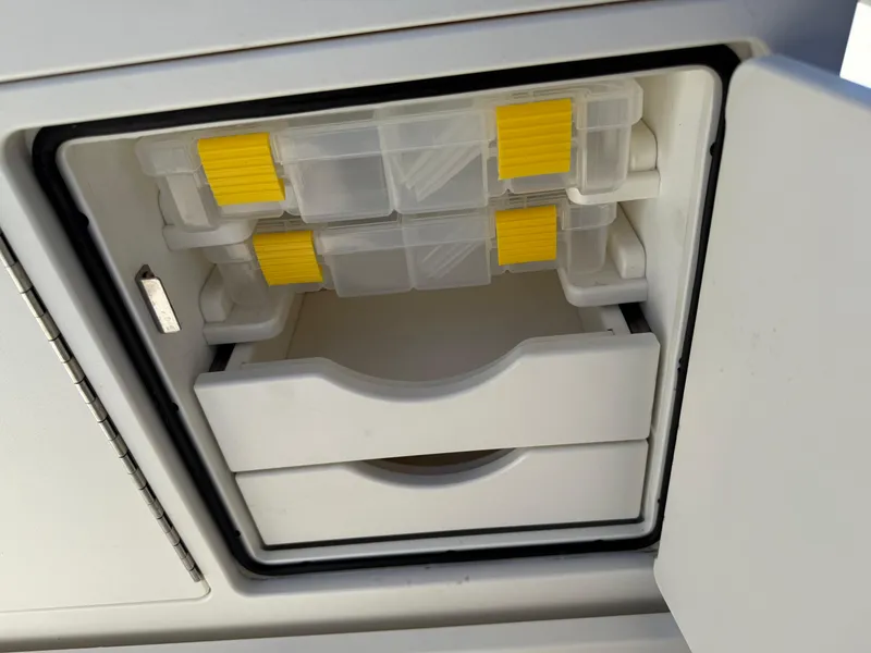 Slide: The Image of Storage compartment on a 2020 Key West 210 BR boat with organized tackle boxes. - 33
