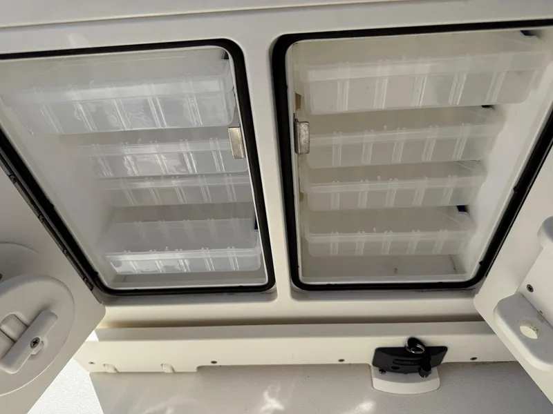 Slide: The Image of Storage compartments on a 2020 Key West 210 BR boat, featuring organized shelving. - 34
