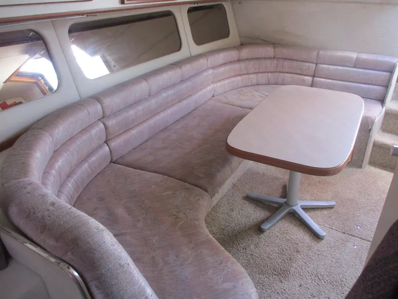 Slide: The Image of 1991 Sea Ray 350 Express Cruiser interior with curved seating and table. - 16