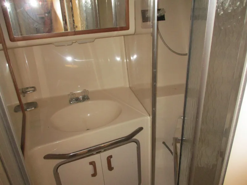 Slide: The Image of 1991 Sea Ray 350 Express Cruiser bathroom with sink, mirror, and shower. - 24