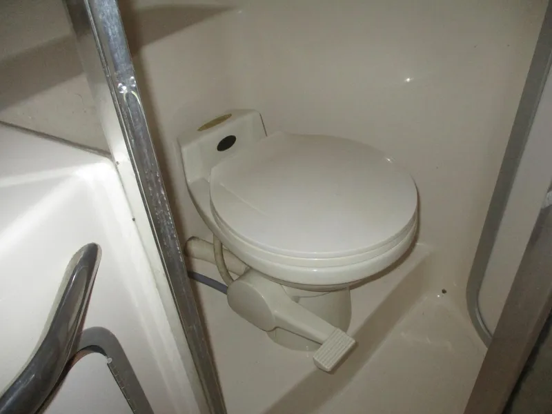 Slide: The Image of 1991 Sea Ray 350 Express Cruiser bathroom with compact marine toilet. - 25