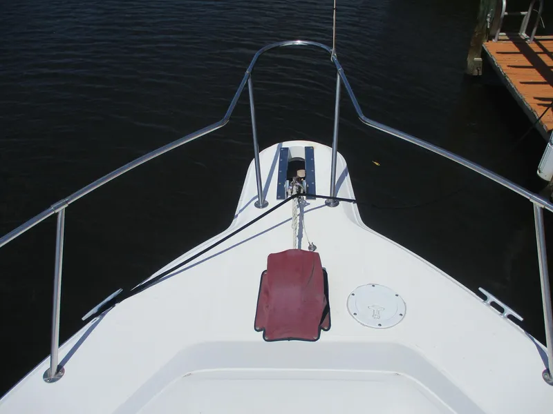Slide: The Image of Bow of a 1991 Sea Ray 350 Express Cruiser on calm water. - 28