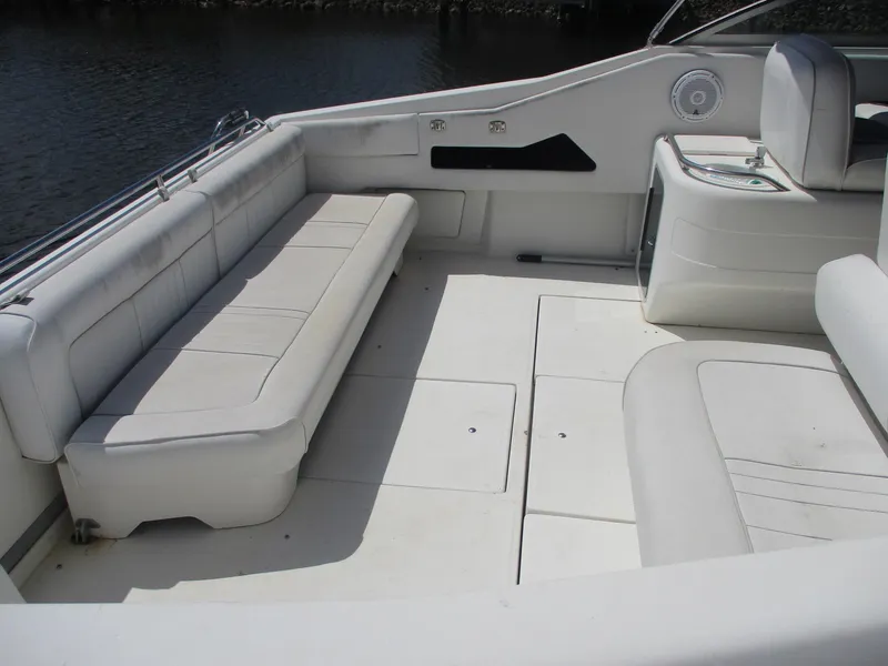 Slide: The Image of 1991 Sea Ray 350 Express Cruiser interior with white seating and spacious deck. - 4